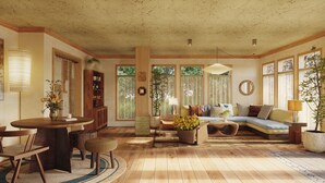 A cozy living room with a wooden floor, a round dining table, a sofa, and a bookshelf. - Oyster Estate (Greenport)