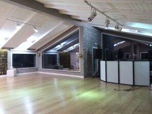 Relax in a spacious room with a high ceiling, open area, and large windows.