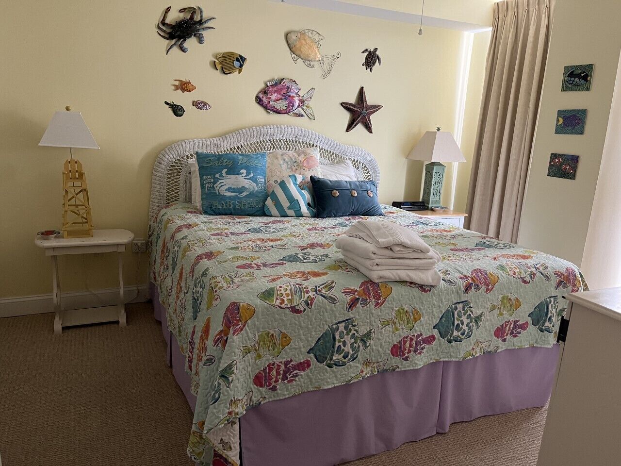 Un dormitorio con cama, mesita de noche, lámpara y adornos en la pared.