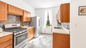 Una cocina moderna con armarios de madera, estufa de acero inoxidable y un refrigerador.