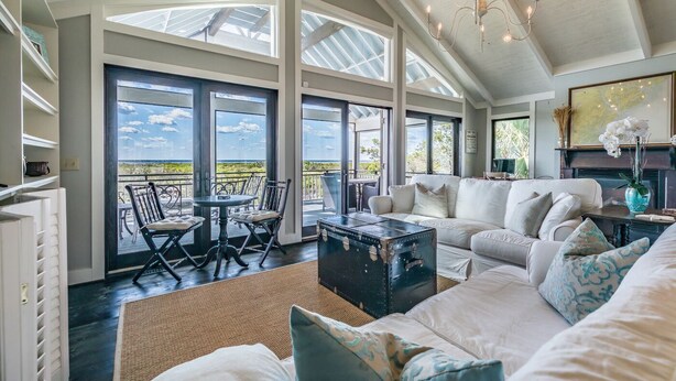 Un salón espacioso con un ventanal grande, una zona de estar acogedora y vistas al exterior.