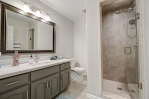 Un baño moderno con tocador, inodoro y ducha a ras de suelo.