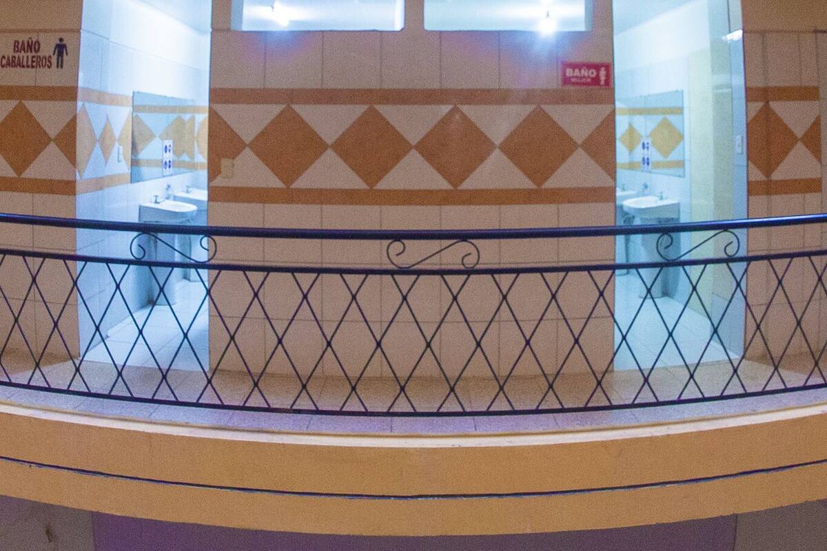 Ein mehrgeschossiges Atrium mit einem offenen Innenbereich, Geländern und Schildern, die Toiletten zeigen.