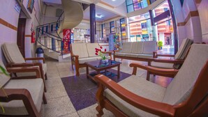 A lobby with wooden chairs, a glass coffee table, and a staircase. - residencial francia - Hostel (Santa Cruz)