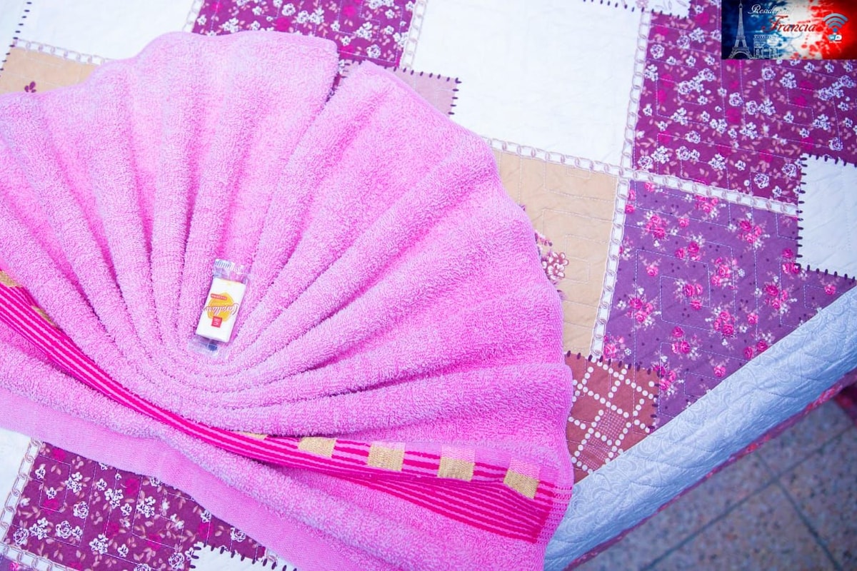 Un abanico rosa sobre una mesa con mantel a cuadros.