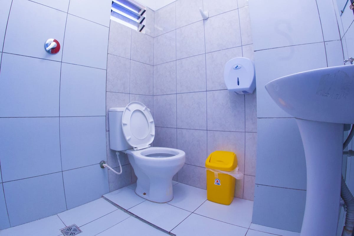 Ein Badezimmer mit Toilette, Waschbecken und Mülleimer.