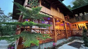Un bâtiment en bois doté d’un balcon et d’un petit jardin.
