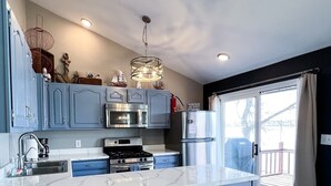 Una cocina moderna con armarios azules, electrodomésticos de acero inoxidable y una isla grande.