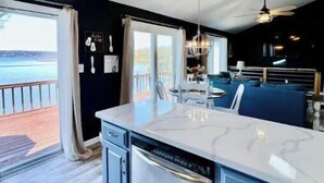 Una cocina moderna con una isla grande, lavavajillas y vistas al exterior.