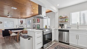 A modern kitchen with white cabinetry, a stainless steel stove, and a dishwasher. - Freshly Renovated Midtown Phoenix Retreat with Pool (Phoenix)