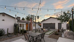 A patio with a table and chairs, a barbecue grill, and string lights. - Freshly Renovated Midtown Phoenix Retreat with Pool (Phoenix)
