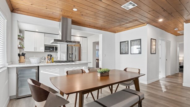 A modern kitchen with white cabinets, stainless steel appliances, and a wooden ceiling. - Freshly Renovated Midtown Phoenix Retreat with Pool (Phoenix)