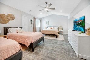 Two single beds with matching headboards and footboards, each with a quilted bedspread, are featured in this minimalist bedroom.