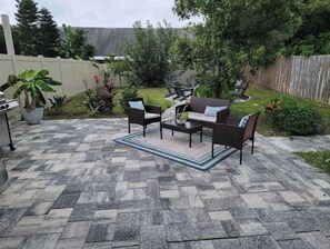 Relax in a serene outdoor space surrounded by lush greenery and a cozy seating area.