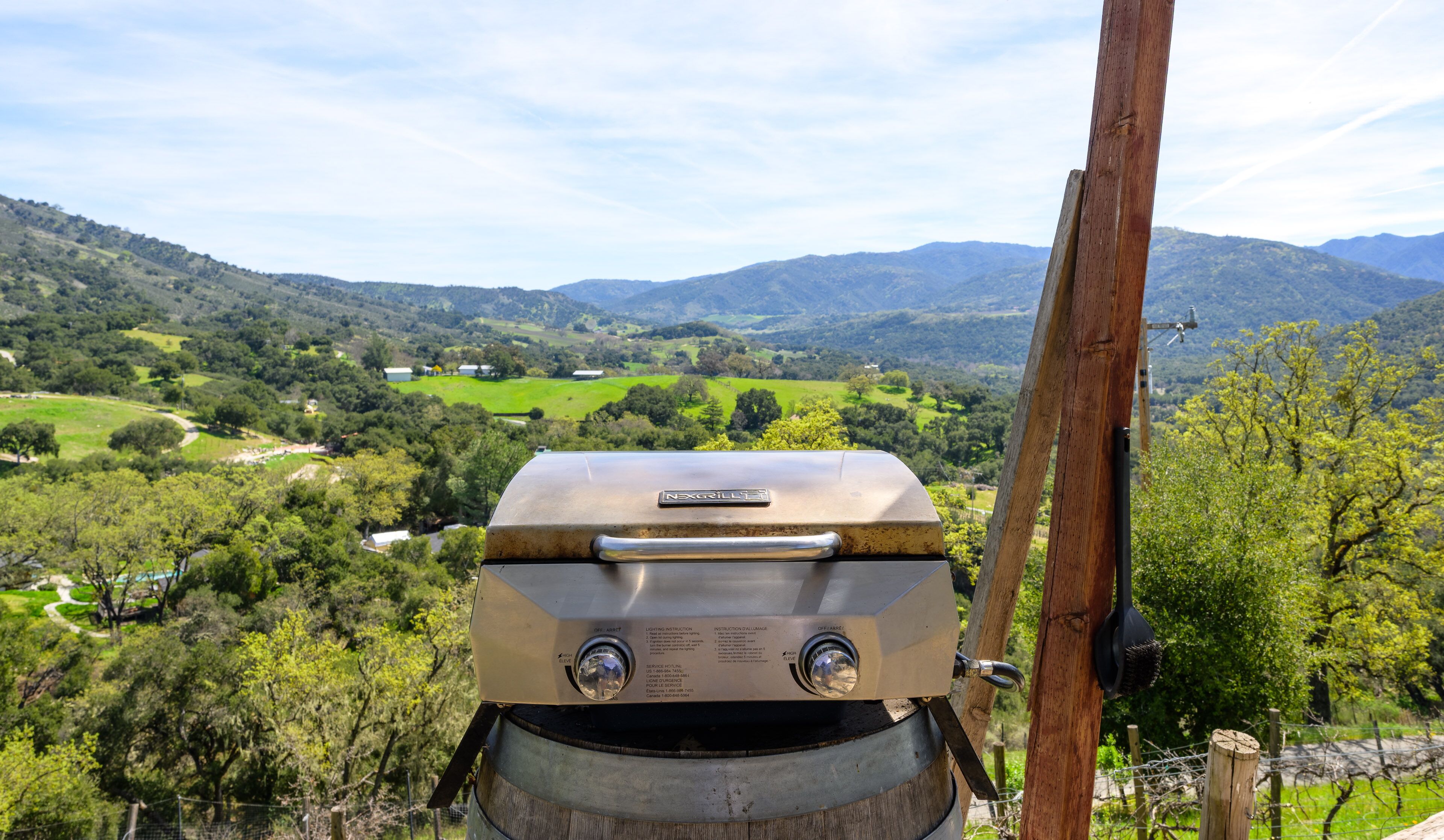 A NEXGRILL barbecue grill with a view of a rural landscape.