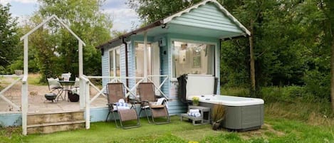 Une petite construction à un seul étage, dotée d’un porche, d’un jacuzzi et d’un espace salon extérieur.