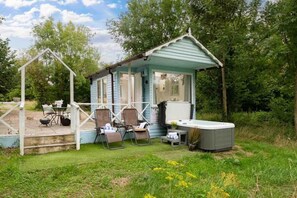 Une petite construction à un seul étage, dotée d’un porche, d’un jacuzzi et d’un espace salon extérieur.