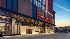Un hotel moderno con un letrero llamativo que dice "RAMADA BY WYNDHAM".