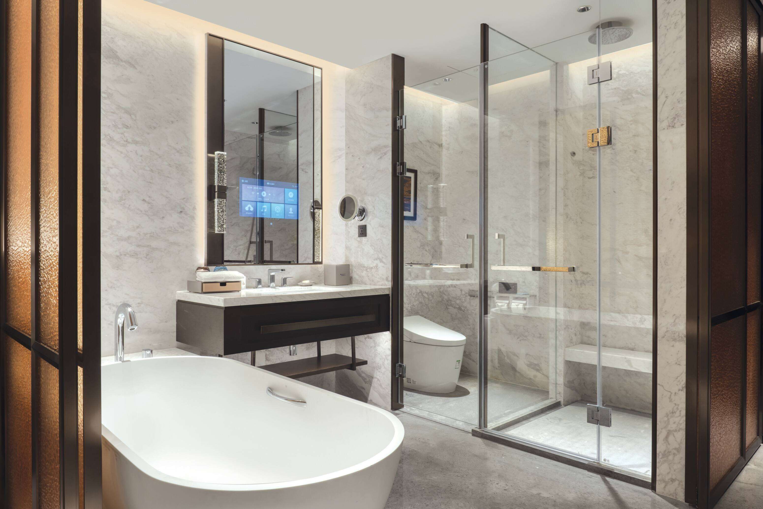 A modern bathroom with a freestanding bathtub, a glass-enclosed shower, and a vanity with a mirror and sink.