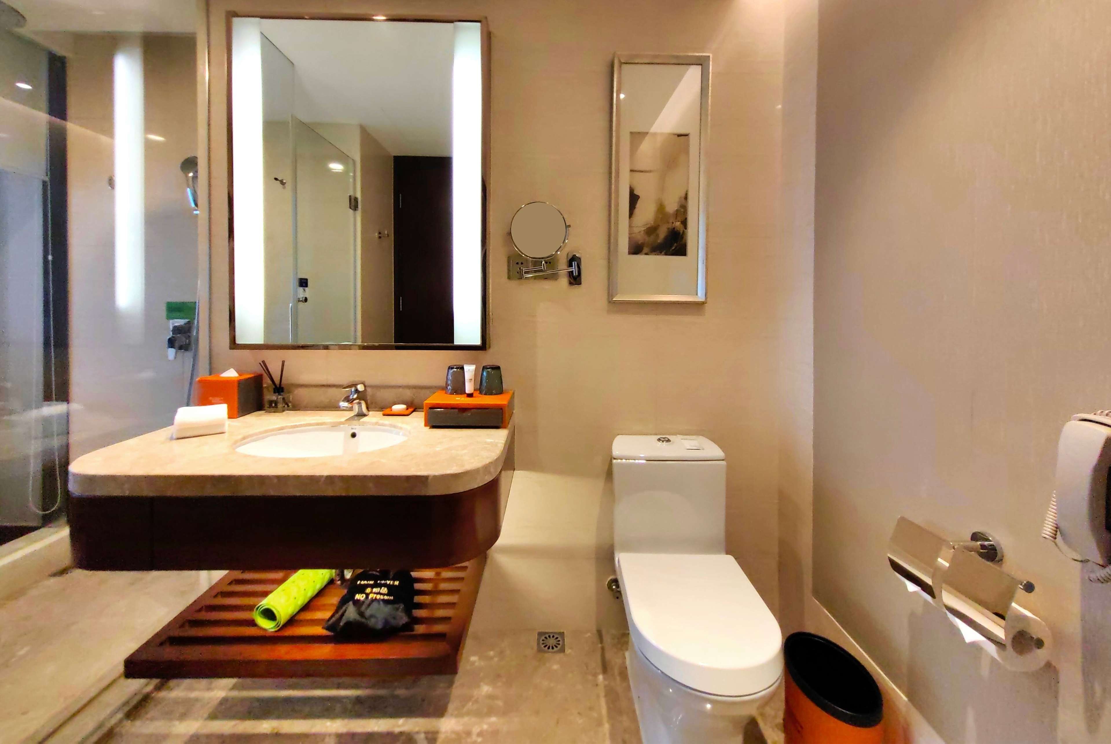 Un baño moderno con tocador de doble lavabo, inodoro, zona de ducha y espejo.