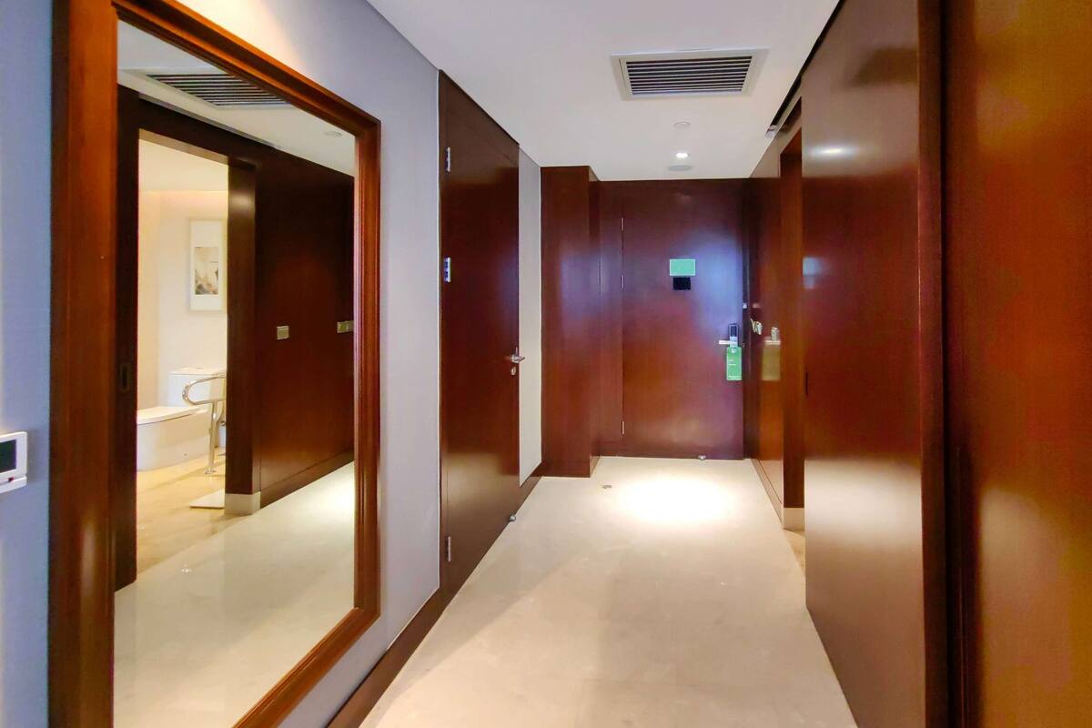 A corridor with wooden doors and a light-colored floor.