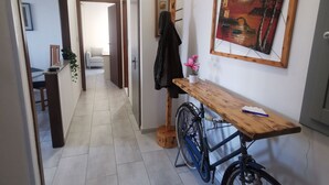 A hallway with a wooden table, a bicycle, and a painting on the wall. - Lovely view - apartment (Albizzate)