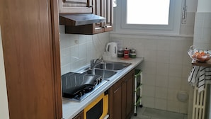 A kitchen with wooden cabinets, a stainless steel sink, a microwave, and a window with blinds. - Lovely view - apartment (Albizzate)