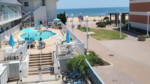 Un hotel con piscina, area salotto esterna e vista sulla spiaggia.