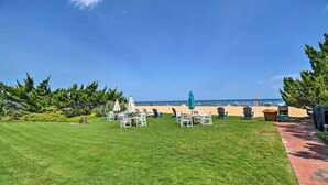 Un prato curato con posti a sedere all'aperto e vista sulla spiaggia.