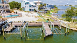 A waterfront property with a swimming pool, multiple decks, and a dock extending into the water.