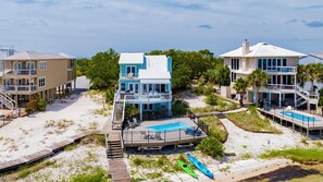 A beachfront property with a pool, multiple decks, and a beach access walkway. - Waterfront | Pet Friendly | Private Pool | Pier | Boat Slip (Perdido Key)