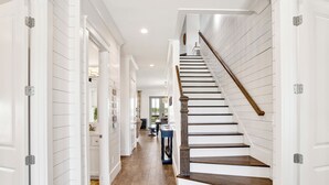 A staircase with wooden steps and a handrail, leading to an upper floor. - Luxury Retreat | Private Pool | Resort Style Amenities (Gulf Shores)