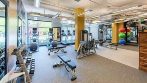 A gym with treadmills, dumbbells, and exercise balls. - Stylish Comfort Meets Spacious Design (Arlington)