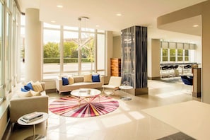 A spacious lobby with a sofa, chairs, a coffee table, and a patterned rug. - Stylish Comfort Meets Spacious Design (Arlington)