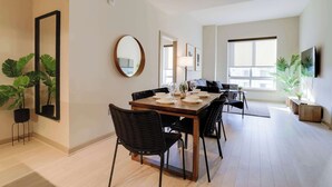 A dining area with a wooden table, black chairs, and a mirror on the wall. - Stylish Comfort Meets Spacious Design (Arlington)