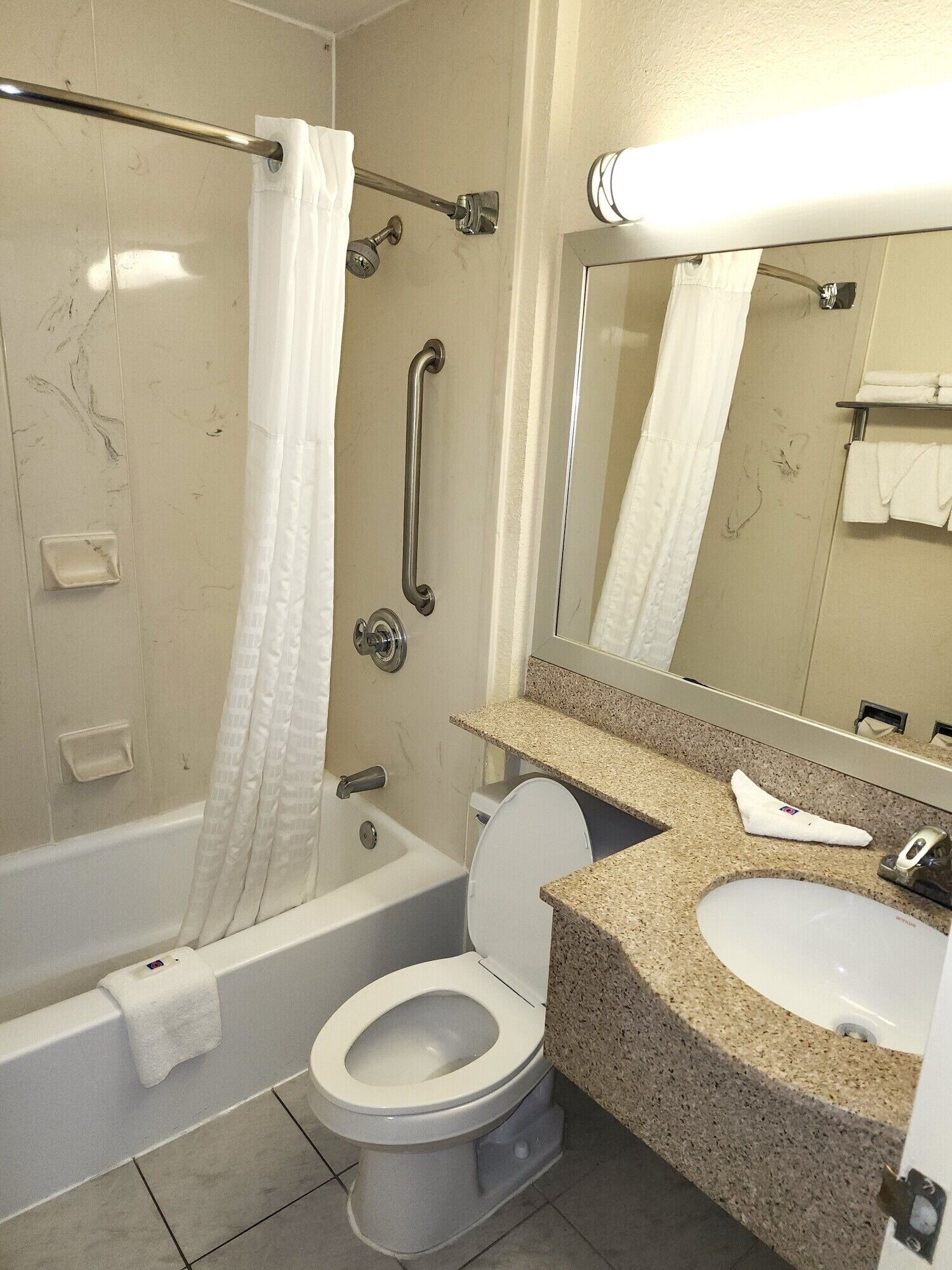 A bathroom with a bathtub, toilet, and sink.