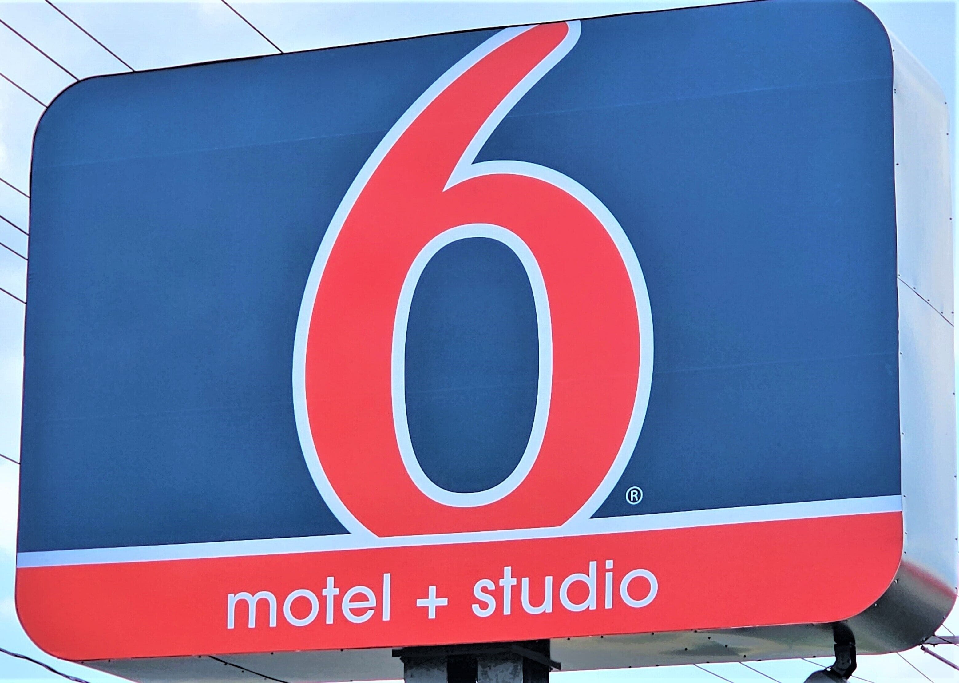 Ein Schild eines Motels mit der Nummer 6 und der Aufschrift 'Motel + Studio'.