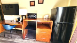 A compact kitchenette with a microwave, refrigerator, and a small table with a chair. - Studio 6 Suites Catonsville, Md – Baltimore West (Catonsville)