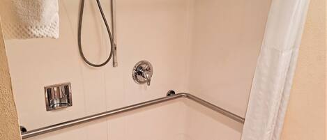 A bathroom with a shower, a toilet, and a sink.