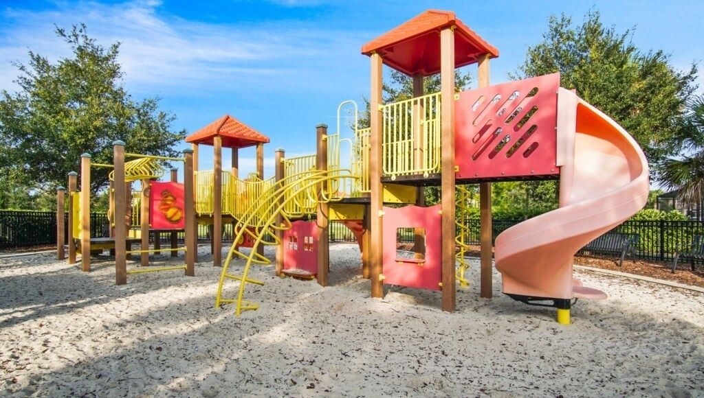 A playground with a slide, climbing structures, and a covered area.