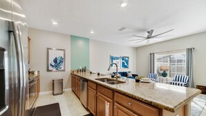 A modern kitchen with granite countertops, stainless steel appliances, and a large island. - Star Hideaway At Storey Lake By Shine Villas 4 Bedroom Townhouse (Kissimmee)