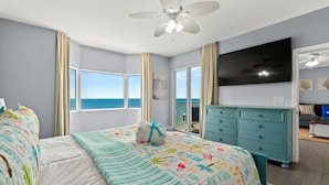 A bedroom with a large bed, a ceiling fan, a TV, and a view of the ocean. - Tidewater Beach Luxury Penthouse With Resort Amenities and a View! (Panama City Beach)