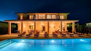 Una casa a due piani con una piscina di fronte.