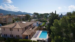 Un resort con piscina, diversi edifici e montagne sullo sfondo.