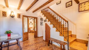 A staircase with wooden steps and a metal balustrade, leading to an upper floor.