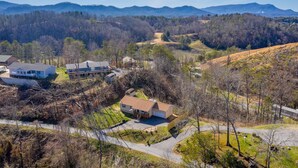 A residential area with houses, a paved driveway, and a mountain backdrop. - Smoky Mountain Abode - #CanPie Rancher# (Sevierville)