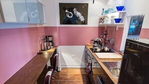 Une cuisine moderne avec un plan de travail en bois, un évier et un réfrigérateur.