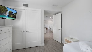 Una habitación de hotel con cama, televisión, armario y escritorio.