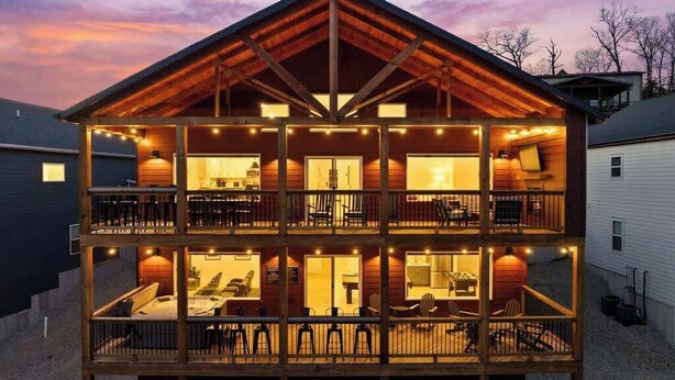 A two-story wooden cabin with a balcony on the ground floor and a dining area on the upper floor. - Lake View|Pools·Hot Tub·Sauna|Game&Theater Rm·18 (Indian Point)