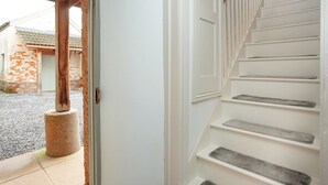 A staircase with white steps and wooden handrails, leading to an interior space.